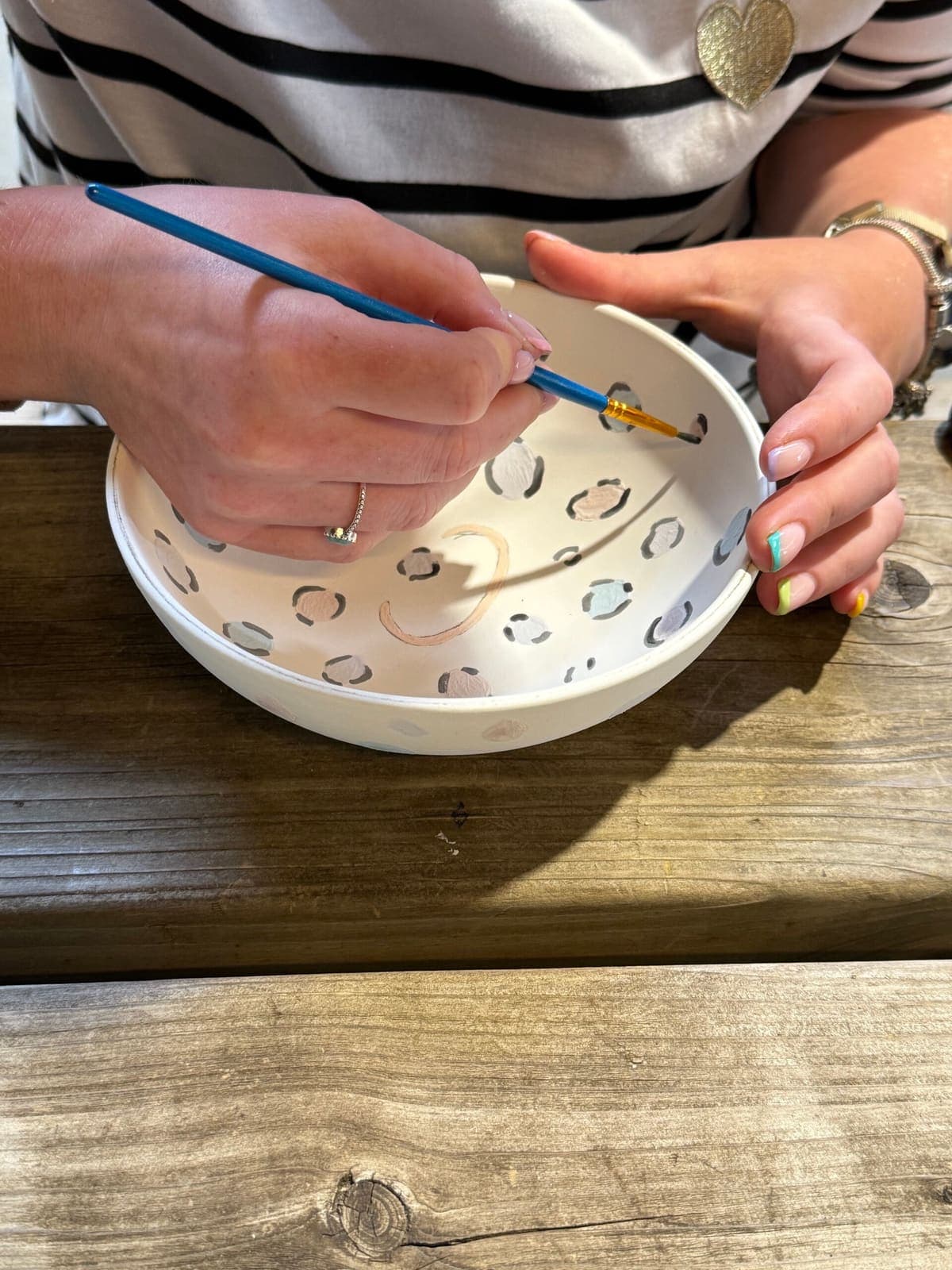 Deelnemer schildert een kom met panterprint tijdens een workshop