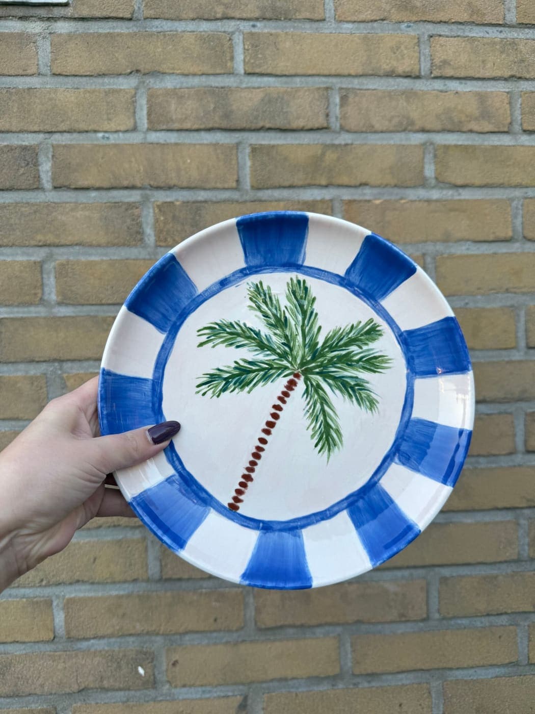 Bord met palmboom en blauwgestreepte rand