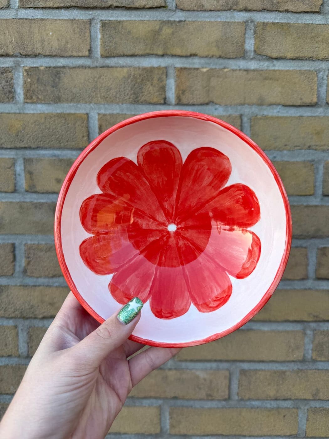 Kom met één grote rode bloem